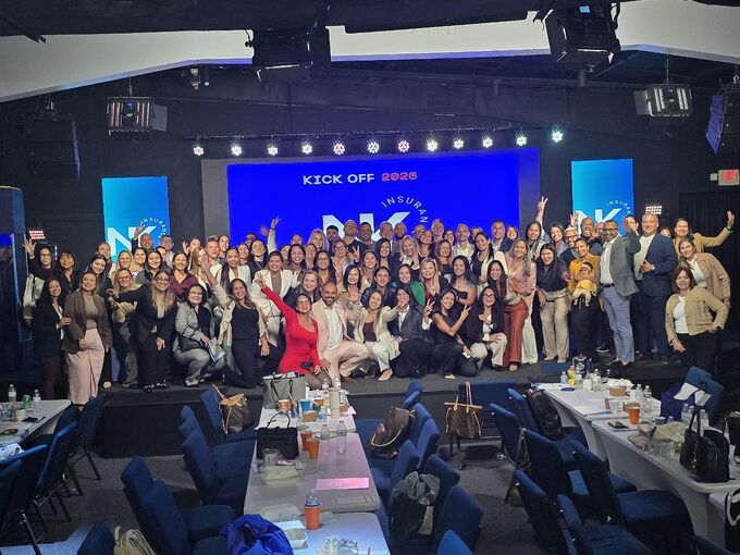 El equipo completo de NK Insurance reunido en el escenario del evento anual Kick Off